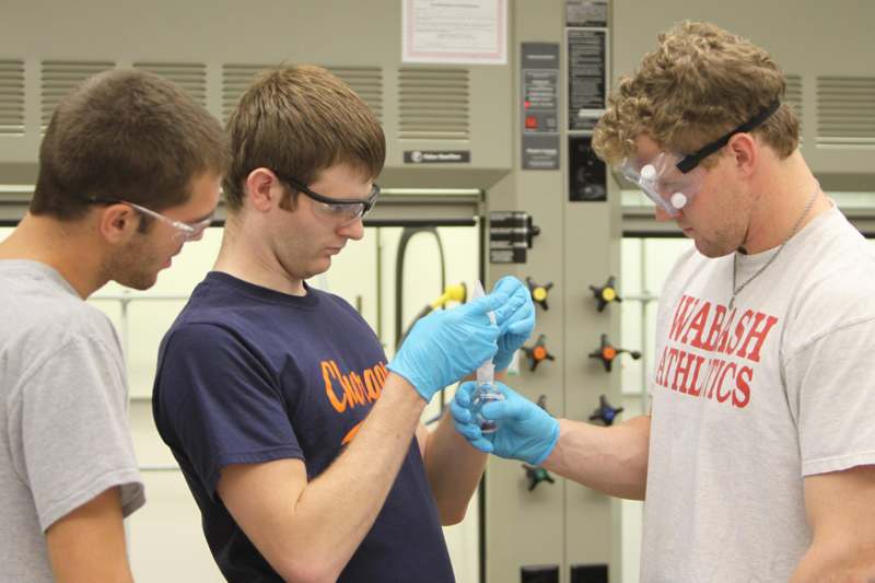 a group of men wearing safety goggles and gloves