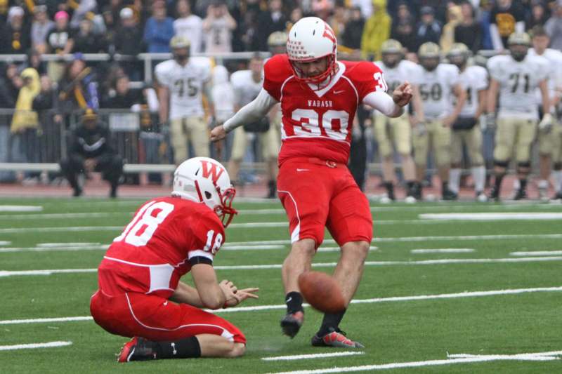 a football player in red uniform kicking a football