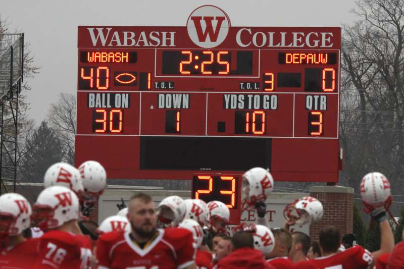 a group of football players in front of a scoreboard