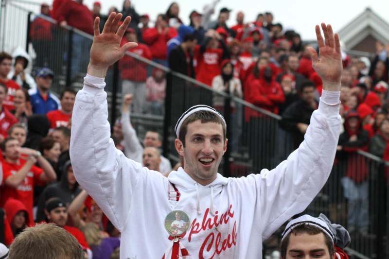 a man in a white sweatshirt with his hands up