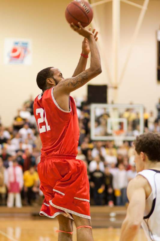 a basketball player in red uniform making a jump shot