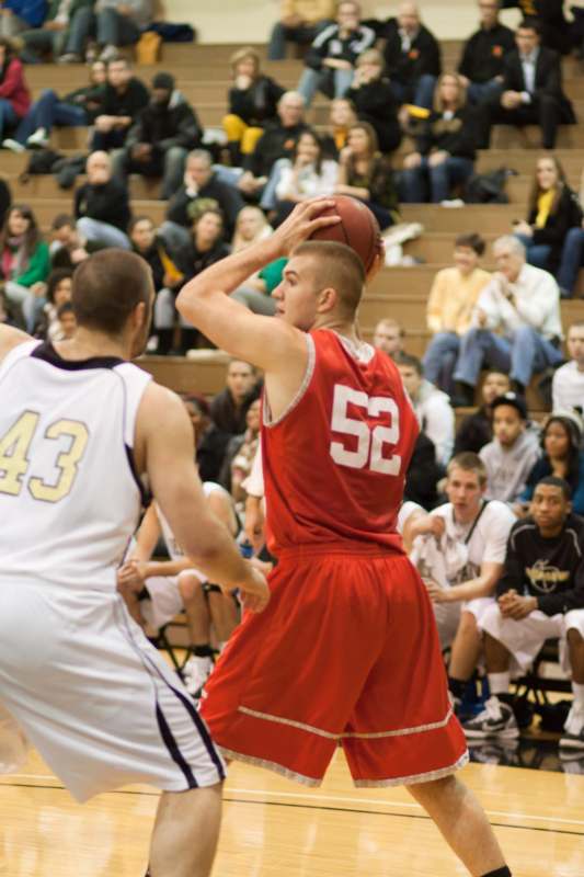 a basketball player in red and white uniform with a ball in front of a crowd