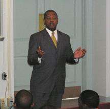 a man in a suit standing in front of a group of people