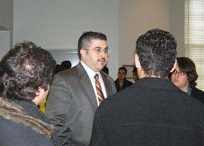 a man in a suit and tie talking to a group of people