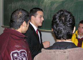 a man in a suit talking to a group of students