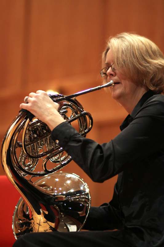 a woman playing a french horn