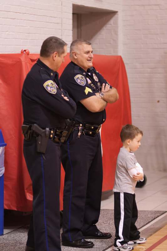 a group of police officers standing in front of a young boy