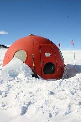 a red dome tent in the snow