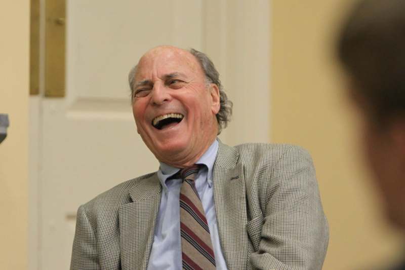 a man laughing in a suit