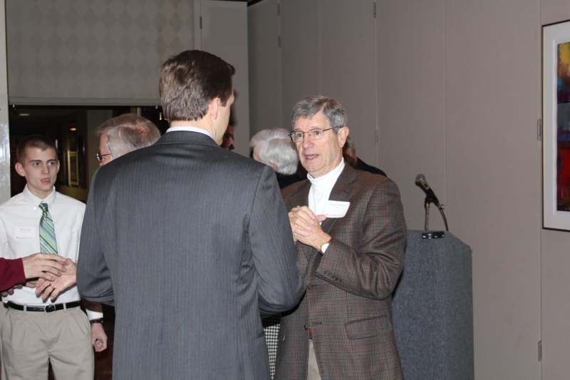 a man in a suit talking to another man