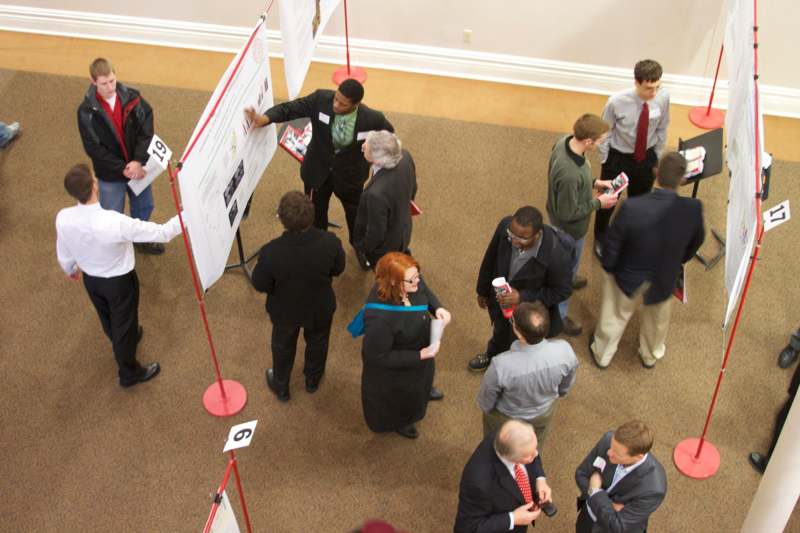 a group of people standing around a white board