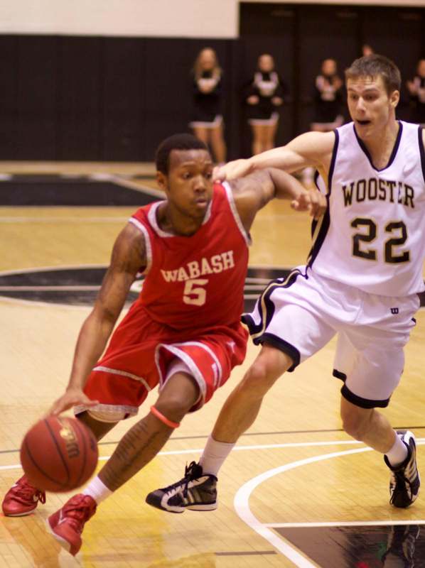 a basketball player in a red uniform dribbling a basketball