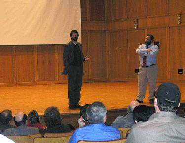 a man standing on stage with a man standing on his lap