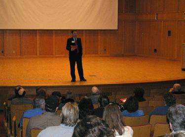 a man standing on stage in front of a crowd