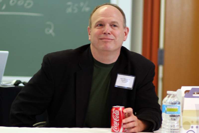 a man sitting at a table with a can of soda