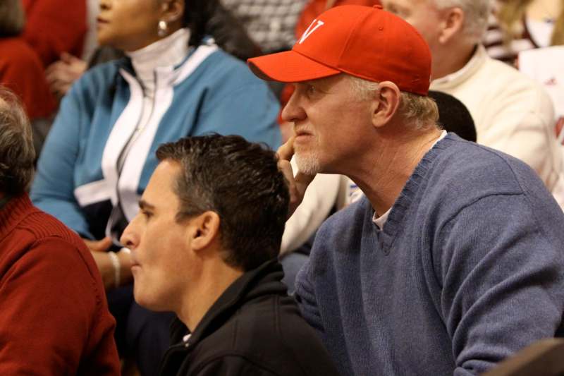 a man in a red hat sitting in a crowd