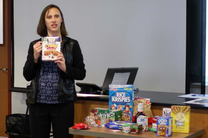 a woman holding a box of cereal