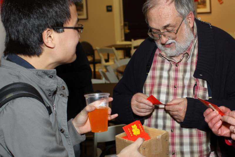 a man holding a red packet and a man holding a red packet
