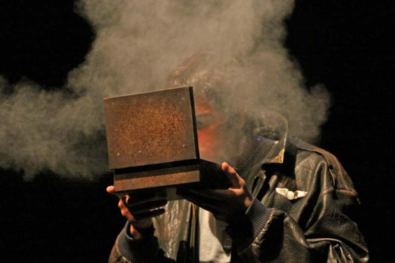a man holding a box with smoke coming out of his mouth