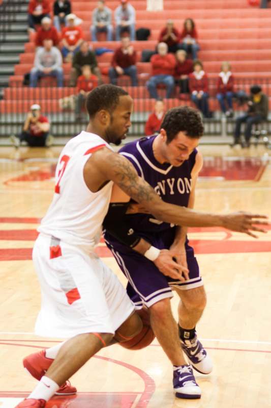 a basketball player in a purple uniform with another player in the back