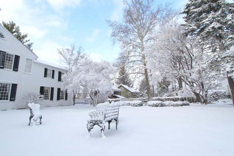 a snow covered park in front of a house