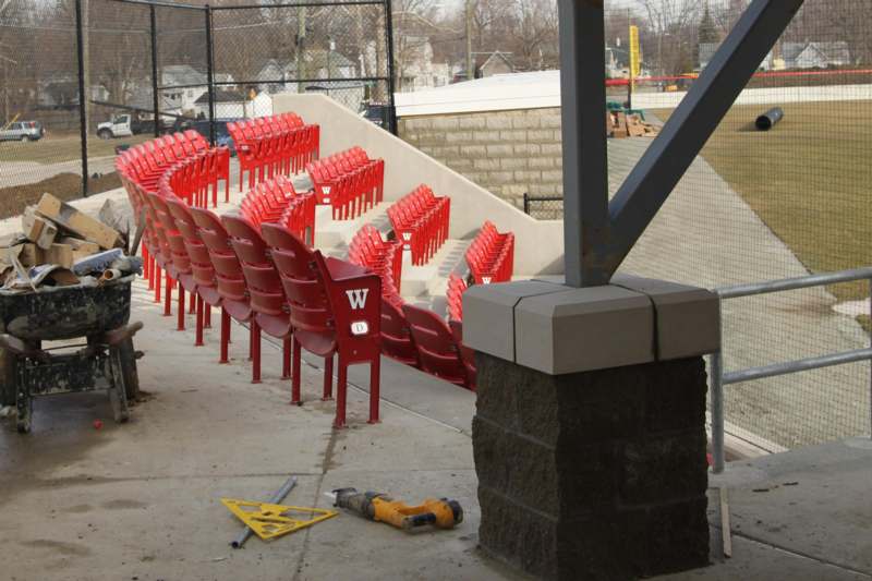 a stadium seating with a brick wall and a fence
