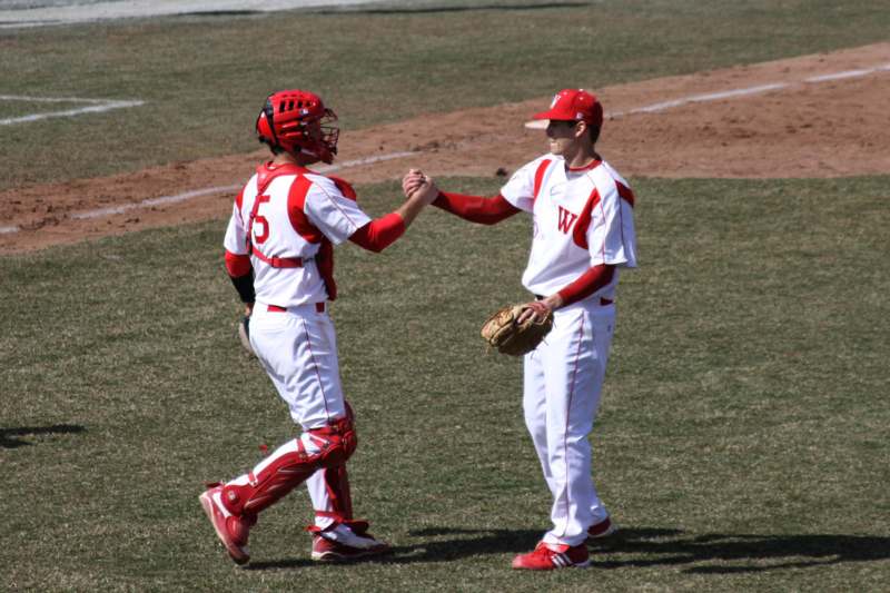 a baseball players shaking hands on a field