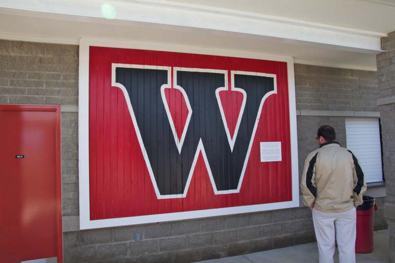 a man looking at a large red and black sign