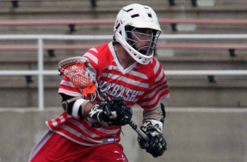 a man wearing a helmet and holding a lacrosse stick