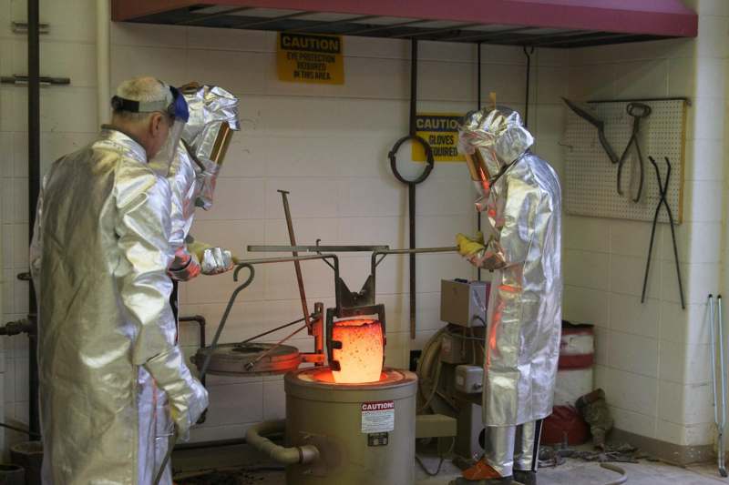 several men in protective suits working in a factory