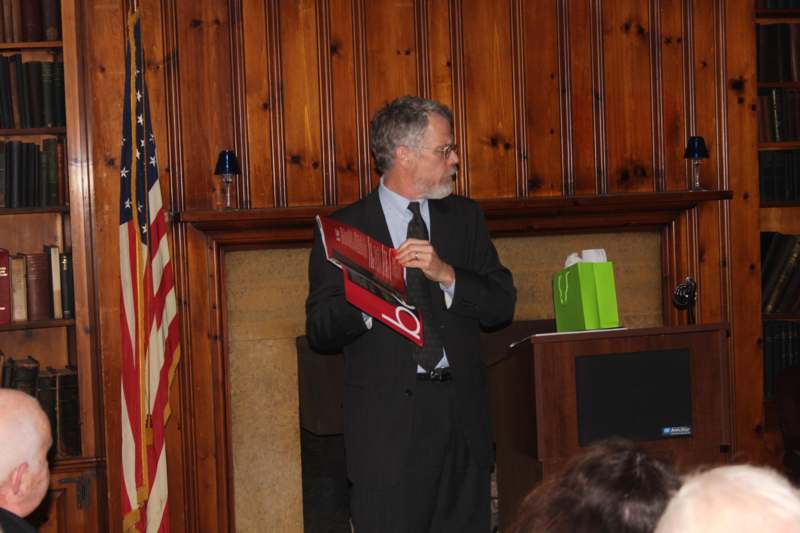 a man in a suit holding a red book
