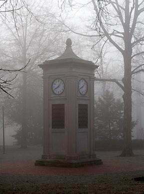 a clock tower in a foggy park