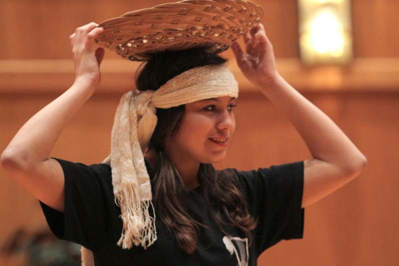 a woman holding a basket on her head