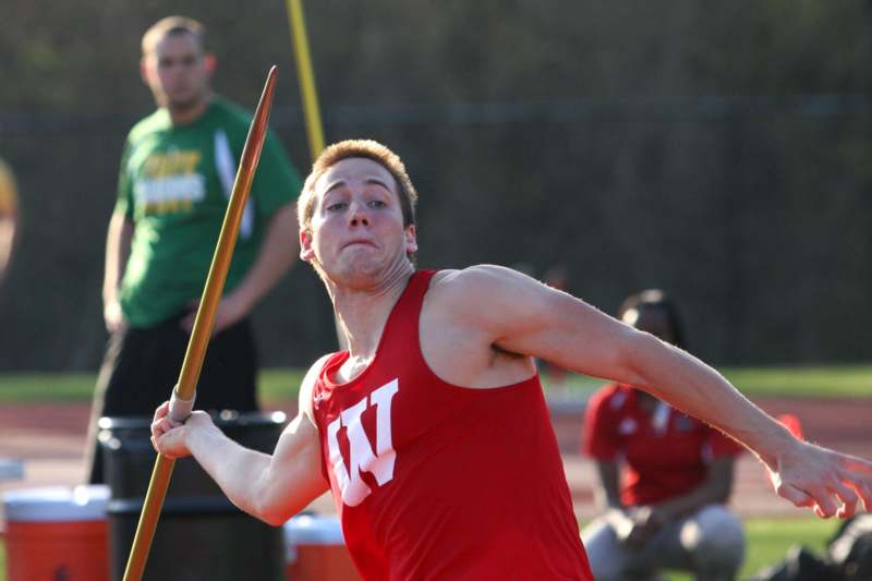 a man in a red shirt holding a javelin
