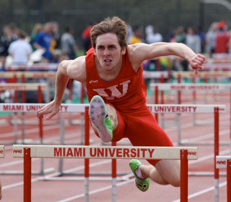 a man jumping over hurdles on a track