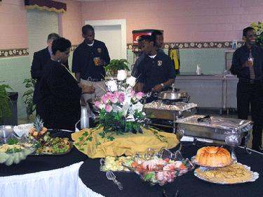 a group of people standing around a buffet