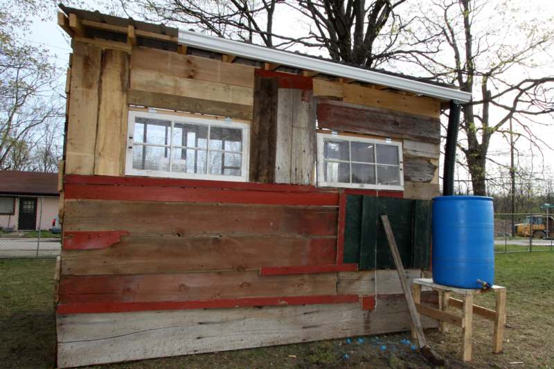 a wooden building with a blue barrel