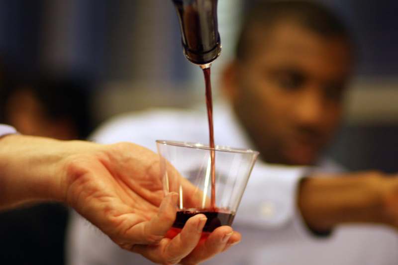 a person pouring a liquid into a glass