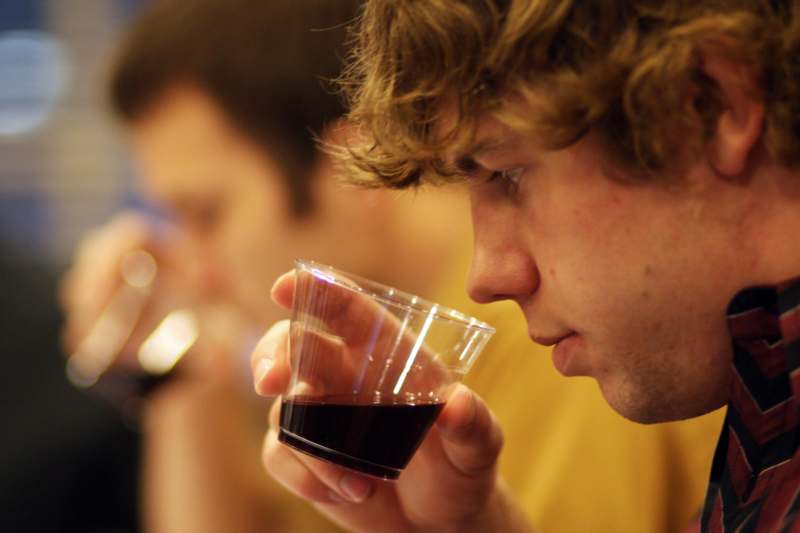 a man drinking from a small glass