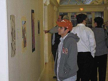 a group of people looking at pictures on the wall