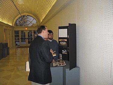 a group of men looking at a display