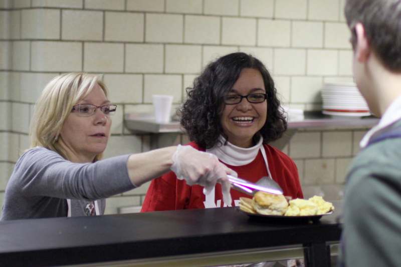 a woman serving food to a woman