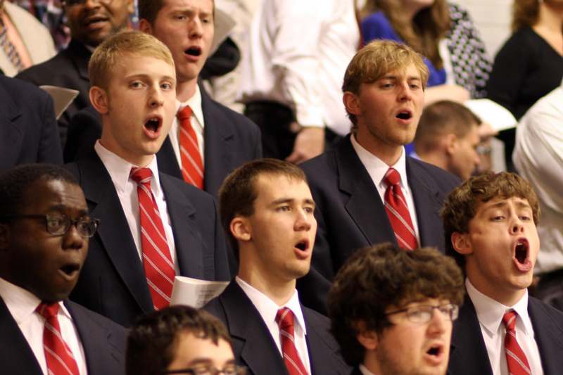 a group of men in suits and ties singing