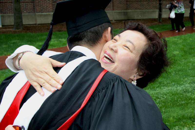 a woman hugging a man in a graduation gown
