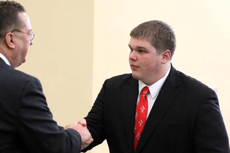 a man in a suit shaking hands with another man in a suit
