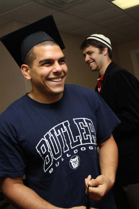 a man wearing a graduation cap and a blue shirt
