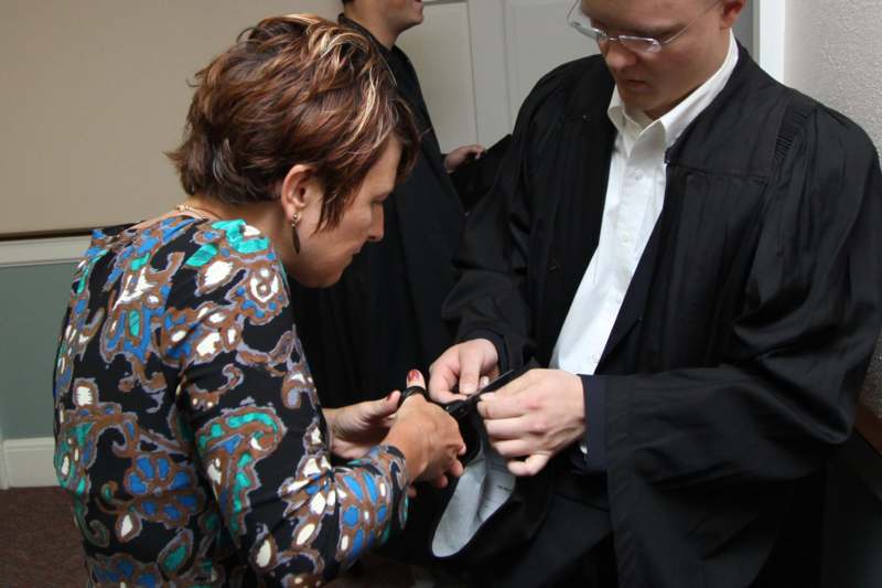 a woman putting on a black robe