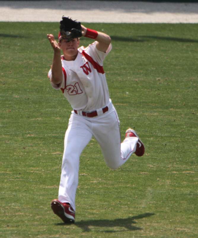 a baseball player in a uniform throwing a baseball