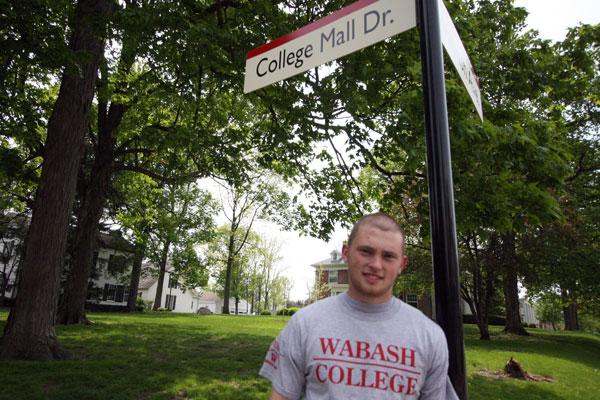 a man standing in front of a street sign