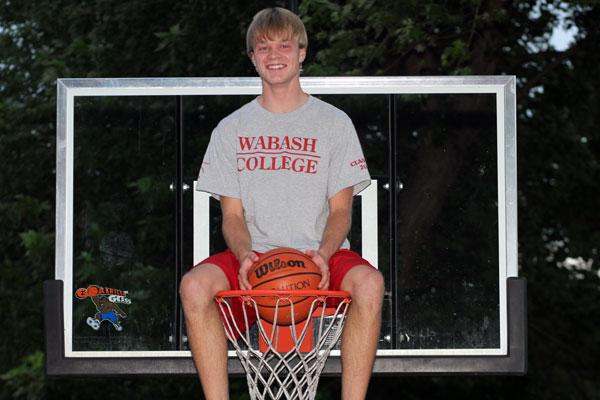 a man sitting on a basketball hoop